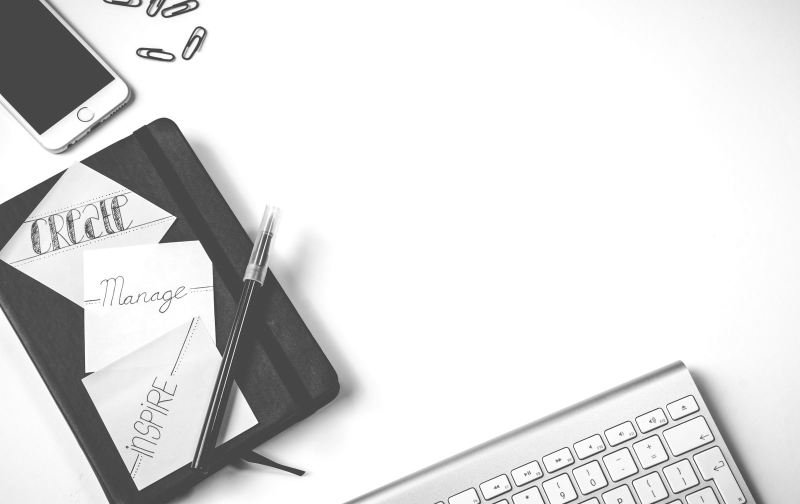 A black notebook and pen on a desk